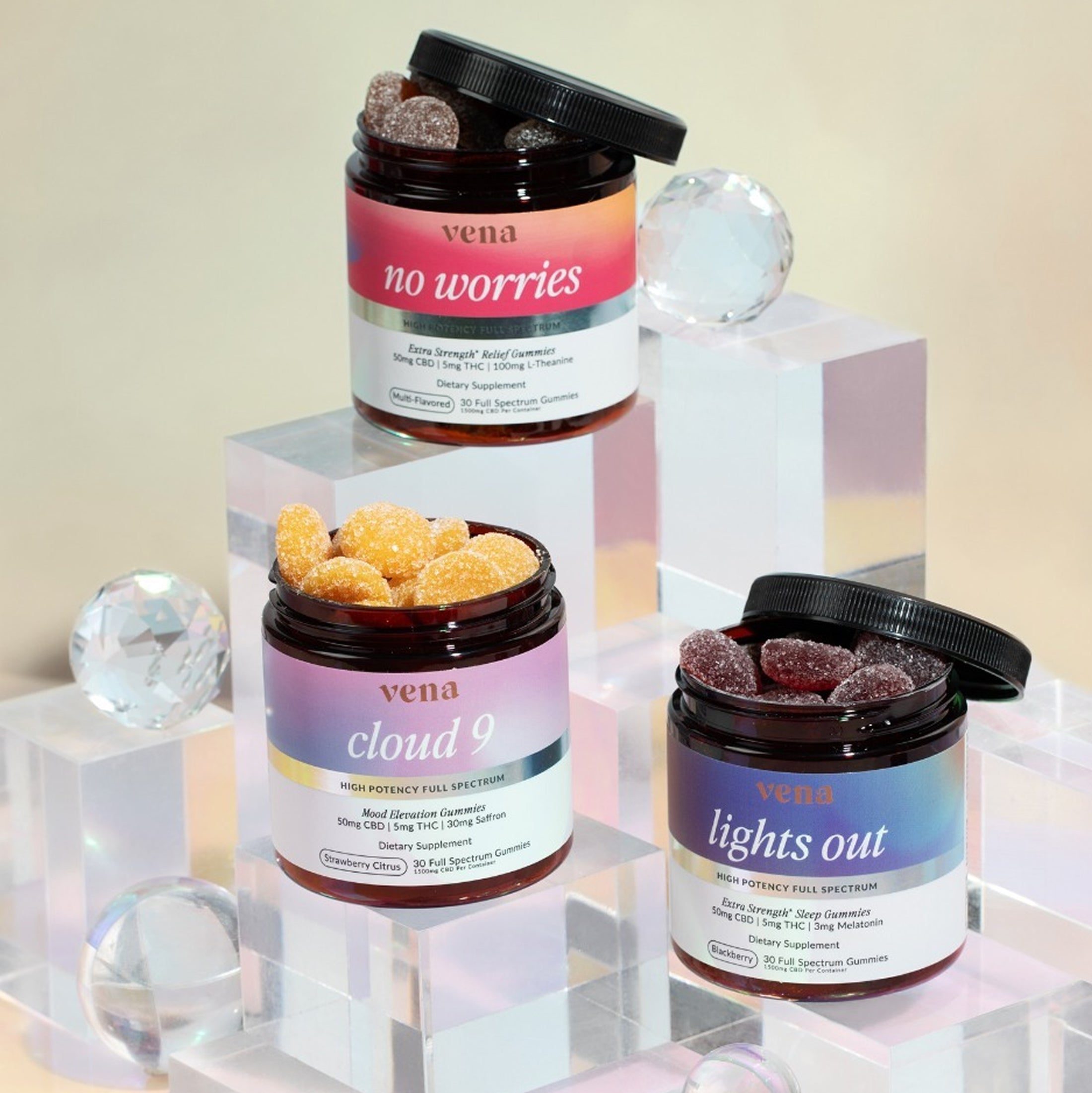 Front view of three open Vena gummy jars showing sugar-coated Delta-9 full-spectrum gummies and colorful labels on a pearlescent display