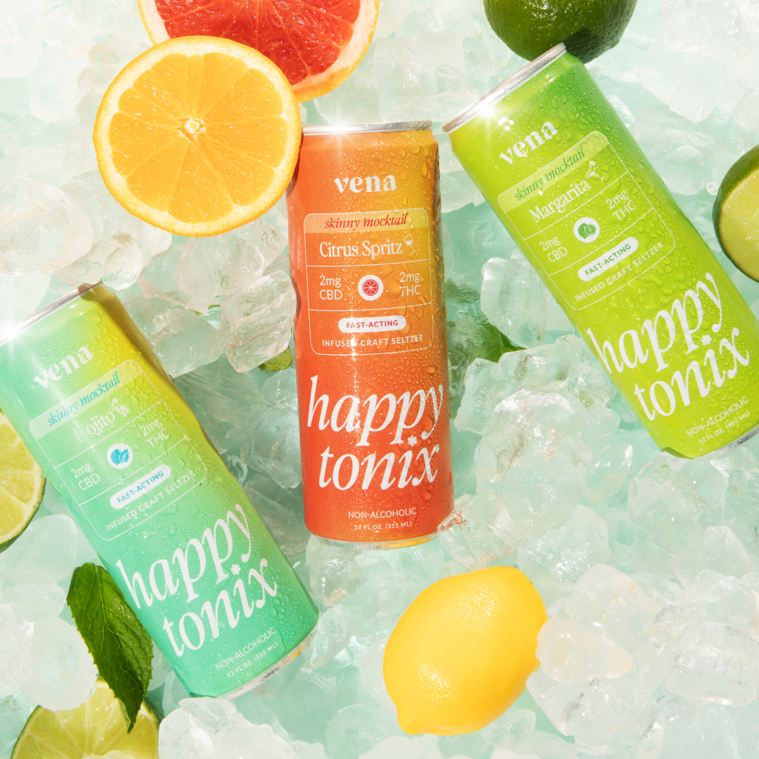 Overhead of three Vena Happy Tonix cans (center Citrus Spritz, right Margarita) chilled on ice with citrus wedges