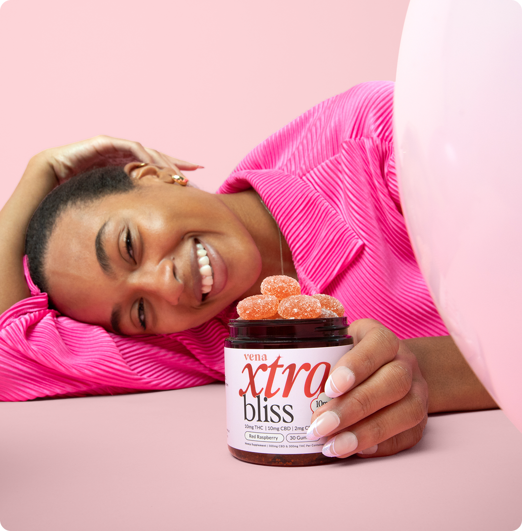 Smiling woman holding jar labeled vena xtra bliss; label reads 10mg THC 10mg CBD 2mg CBN Red Raspberry