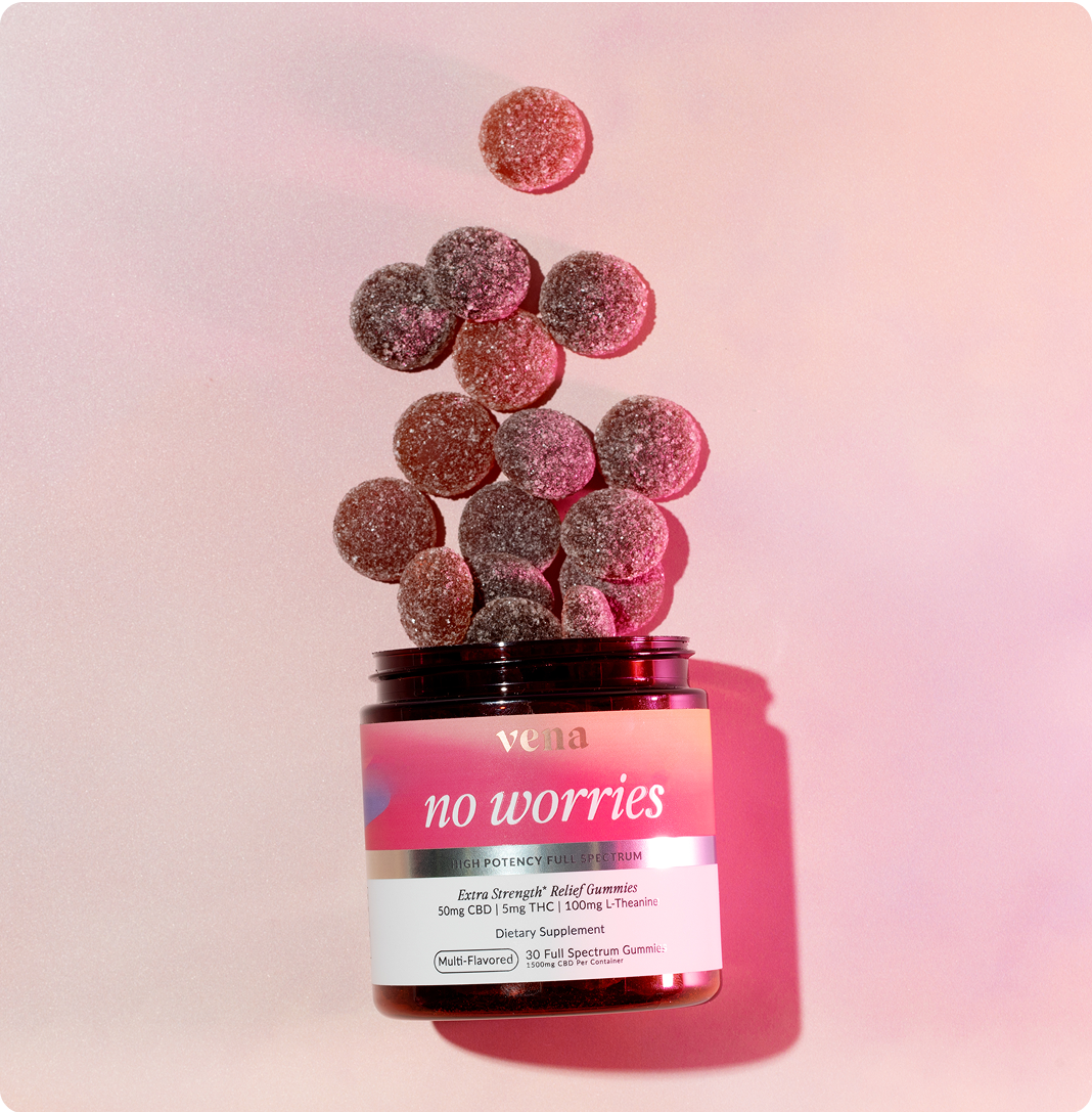 Angled view of open Vena No Worries gummy jar showcasing sugar-coated pink and purple gummies spilling upward on a pale pink background