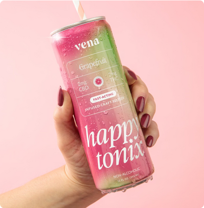Angled can of Happy Tonix Grapefruit seltzer held in hand showing 2mg CBD 2mg THC fast-acting, condensation, pink background