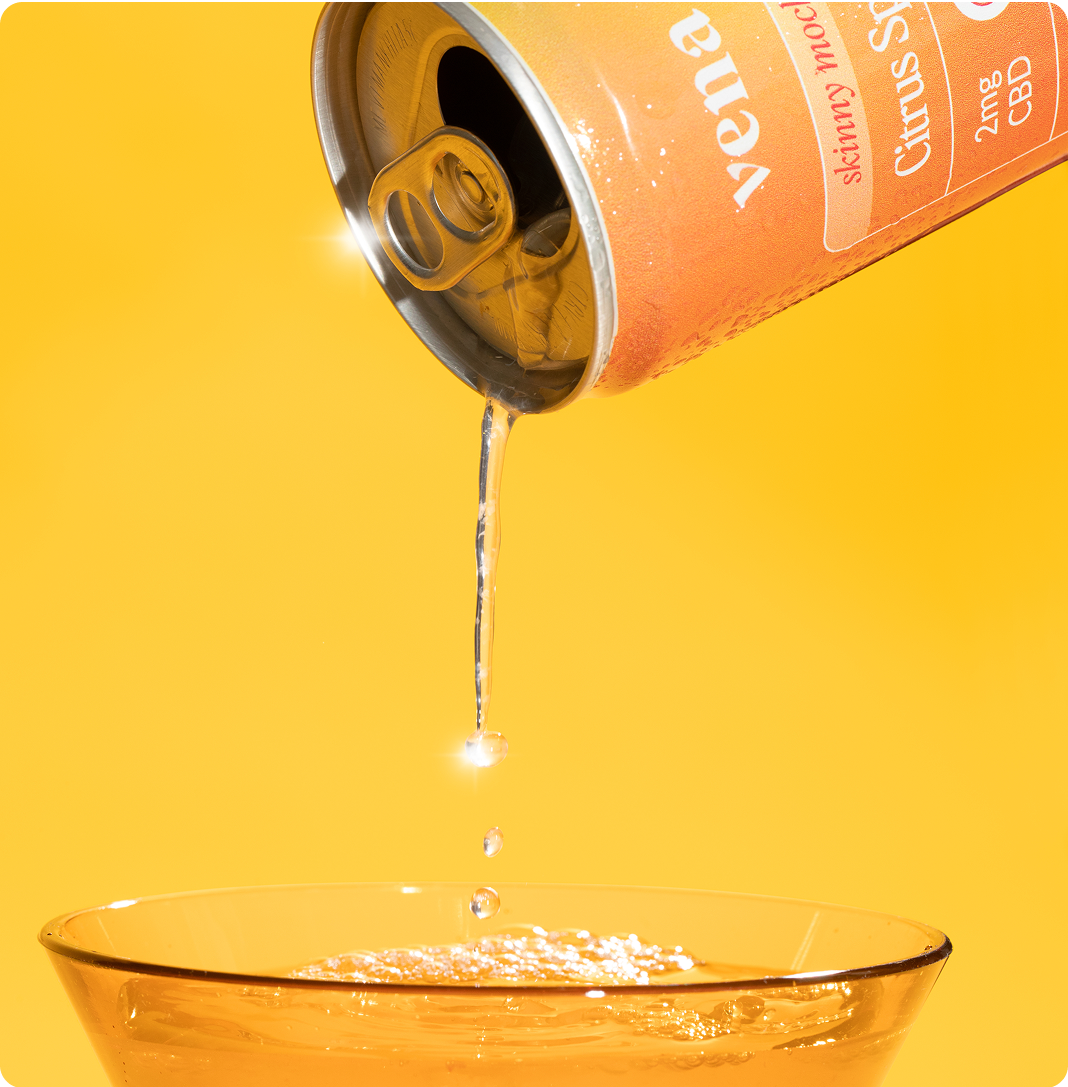 Orange can pouring clear seltzer into a glass; label reads "Skinny mocktails Citrus 2mg CBD"